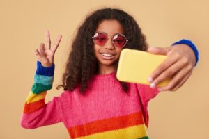 Girl taking a selfie with a yellow phone